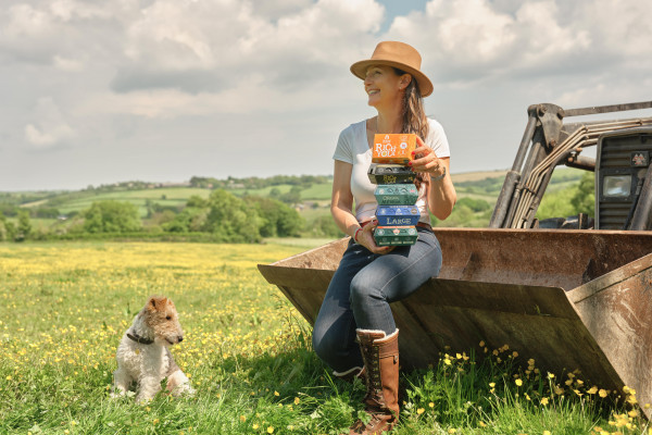 Our CEO, Bex, sat on a tractor, with a dog by her side